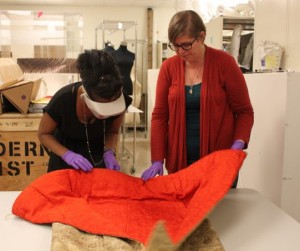 Keidra Daniels Navaroli, left, assistant director and curator at the Ruth Funk Center for Textile Arts, and Director of Collections Sarah Smith inspect an item from the center’s permanent collection.